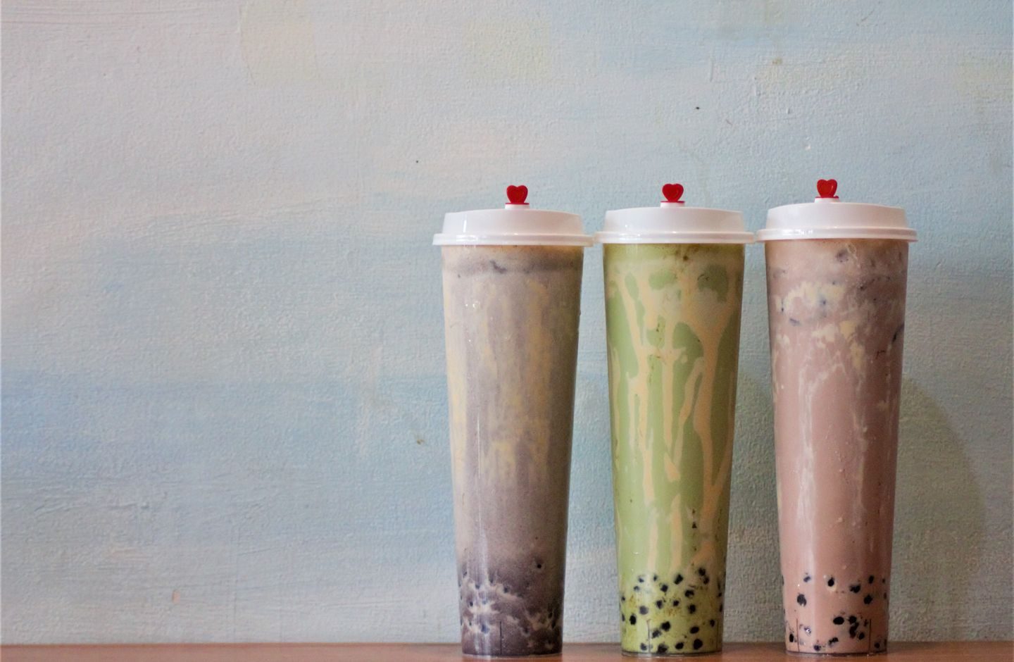 Two cups of Taiwanese bubble tea (boba milk tea) with tapioca pearls visible through the cups.